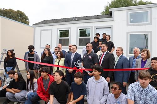Prepairing for Mr. Vidales to officially unveil the tiny home by cutting the ribbon.