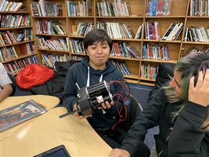 Student holding a component of the robot