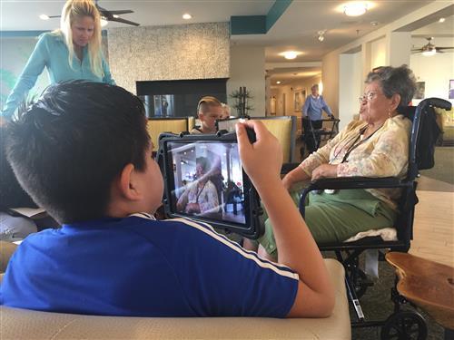 Student filming a senior resident