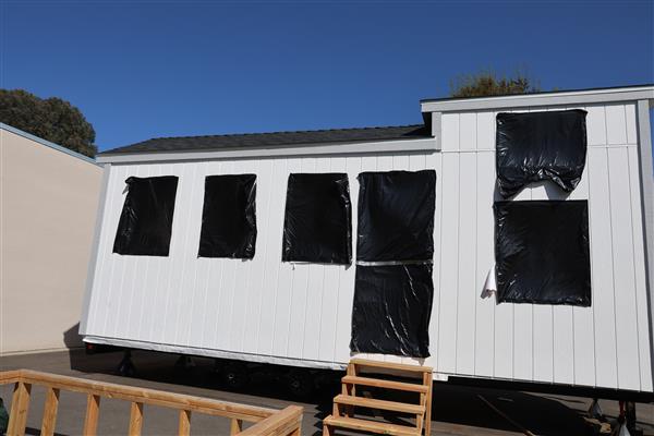 Siding has been installed and windows protected while students work inside on electrical. 