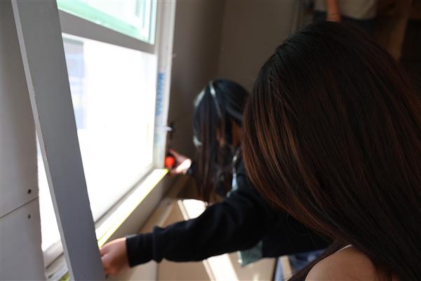 Students working on framing the windows.